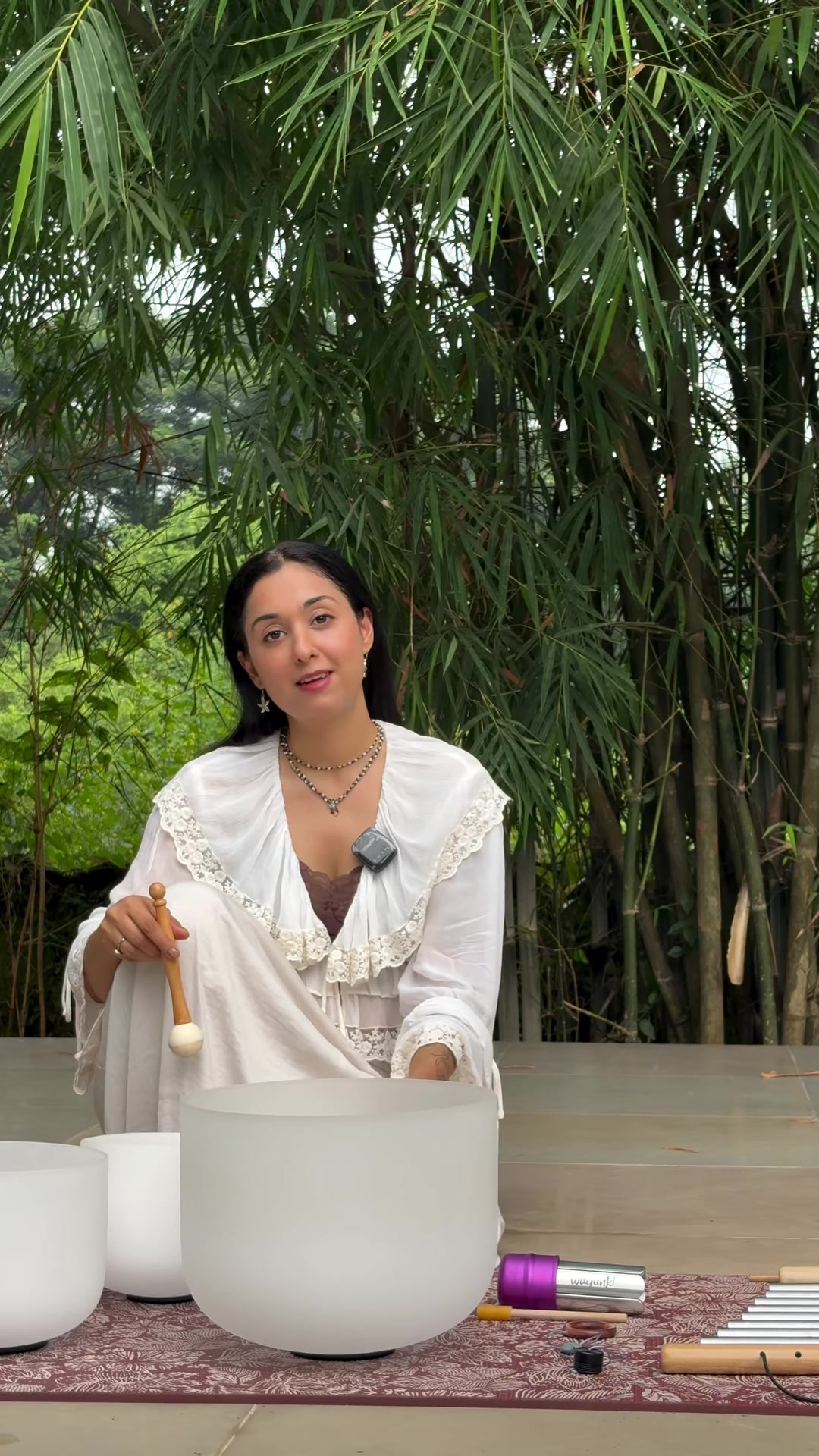 Kareena Vinaik playing crystal singing bowls outdoors